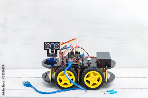 robot on four wheels and a variety of cables with big blue wire