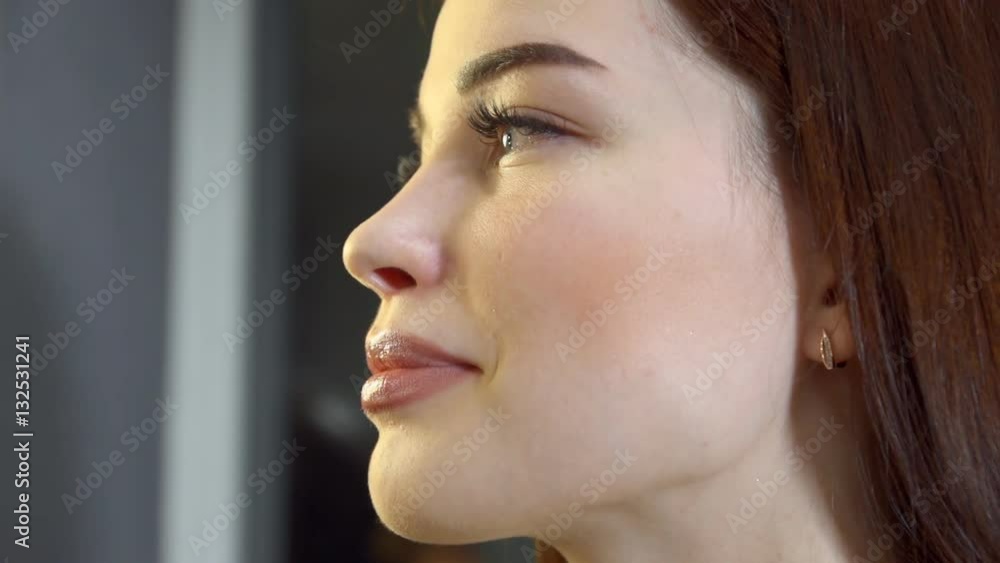 Visagiste applying powder with make up brush to brunette young woman with long hair in beauty salon sitting on a chair next to the mirror. Visagiste applying powder with make up brush to brunette young woman with long hair in beauty salon sitting on a chair next to the mirror.