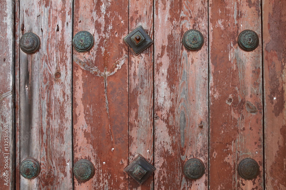 Very old wooden door decorated with forged bronze nails Very old wooden door decorated with forged bronze nails