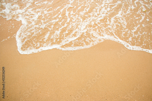 Waves on a sandy beach in the summer.