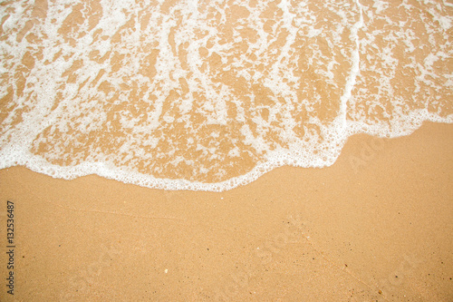 Waves on a sandy beach in the summer.