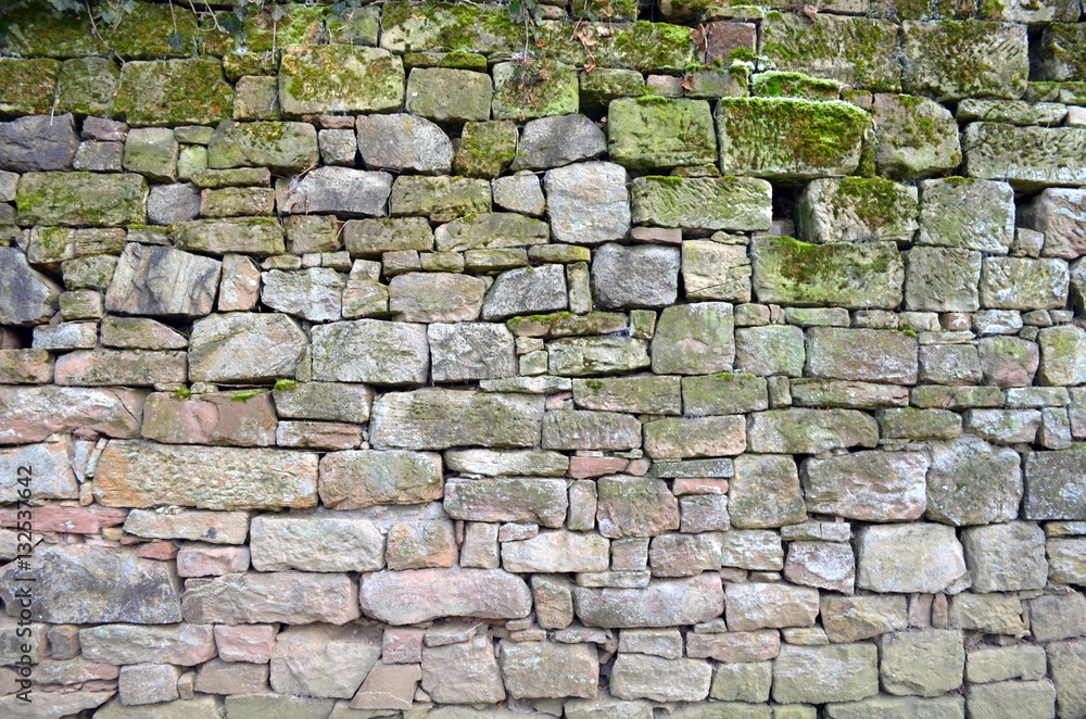Obraz premium Mit Moos bewachsene Natursteinmauer