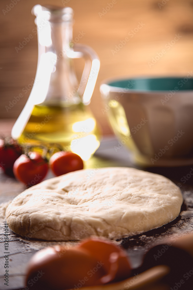 Preparing home pizza on wooden table with ingredients