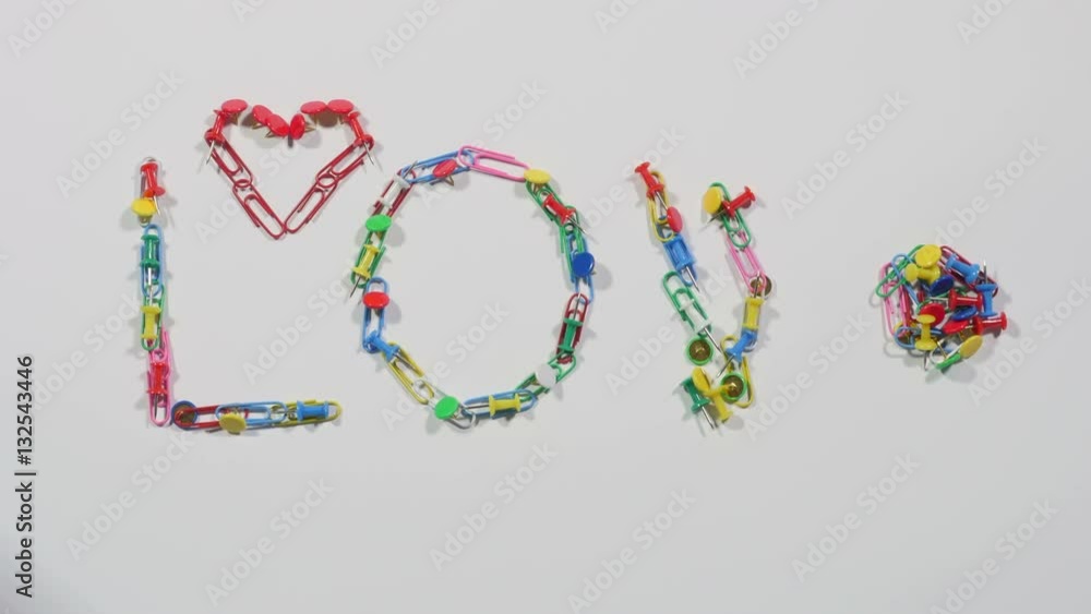 Love and heart made of multicolored paper clips and pins on white surface, office supplies, equipment for paperwork, stationery. Close up, stop motion, 4K Ultra HD. Love and heart made of multicolored paper clips and pins on white surface, office supplies, equipment for paperwork, stationery. Close up, stop motion, 4K Ultra HD.