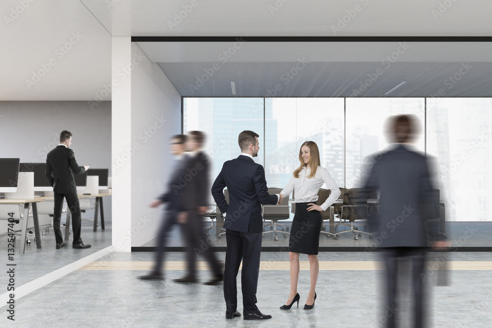 People in open office with meeting room People in open office with meeting room