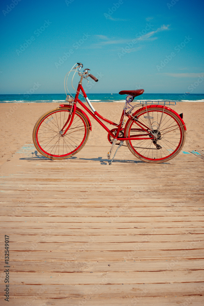Fototapeta premium Retro red bicycle on beautiful beach background