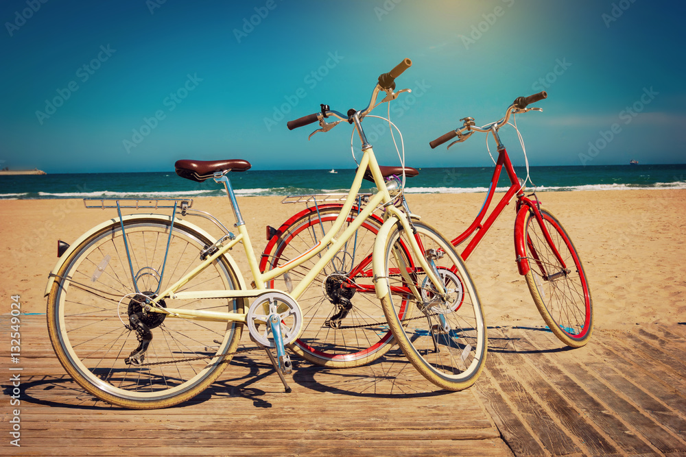 Fototapeta premium Two retro bicycles on beautiful beach background