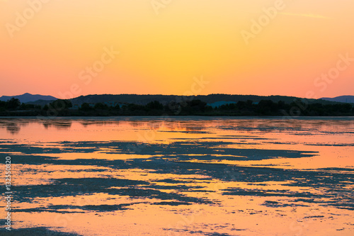 Sunset on the pond of pink flamingos in Chia, Sardinia.