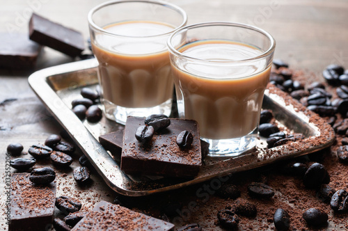  Coffee liqueur, shot glasses with homemade baileys, roasted coffee beans, chocolate, selective focus