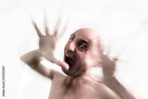 Blurred man suffering from dementia, insanity and schizophrenia, screaming in moment of fury, hallucination and nightmare
