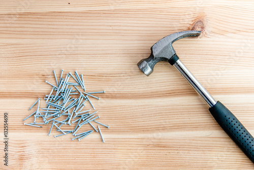 Foto Hammer and nails on a wooden background