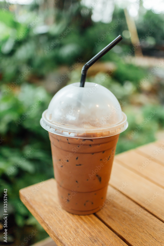 Ice coffee on a wooden table.Flim tone color Ice coffee on a wooden table.Flim tone color