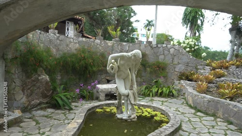 Stones white scuipture of beautiful woman with jug in the artificial pond photo