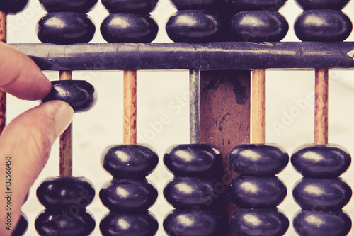 Behang close up image of hand accounting with old abacus
