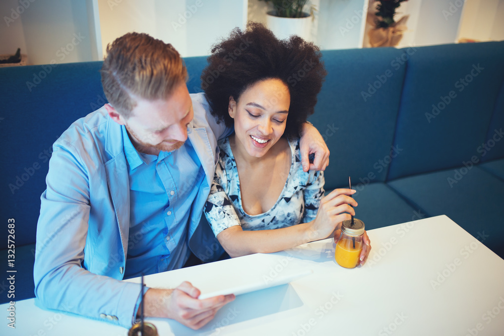 Obraz premium Multiracial couple dating. Handsome redhead man with beautiful Afro american woman having some good time in cafe bar or restaurant.