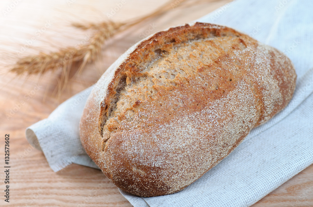 fresh loaf of bread on  wooden background, closeup view