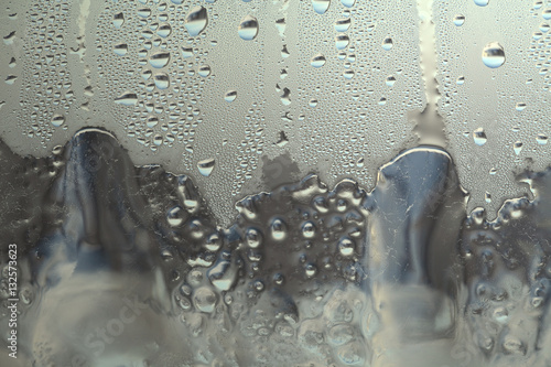 Лед на оконном стекле, текстура с каплями от дождя с серых цветах.