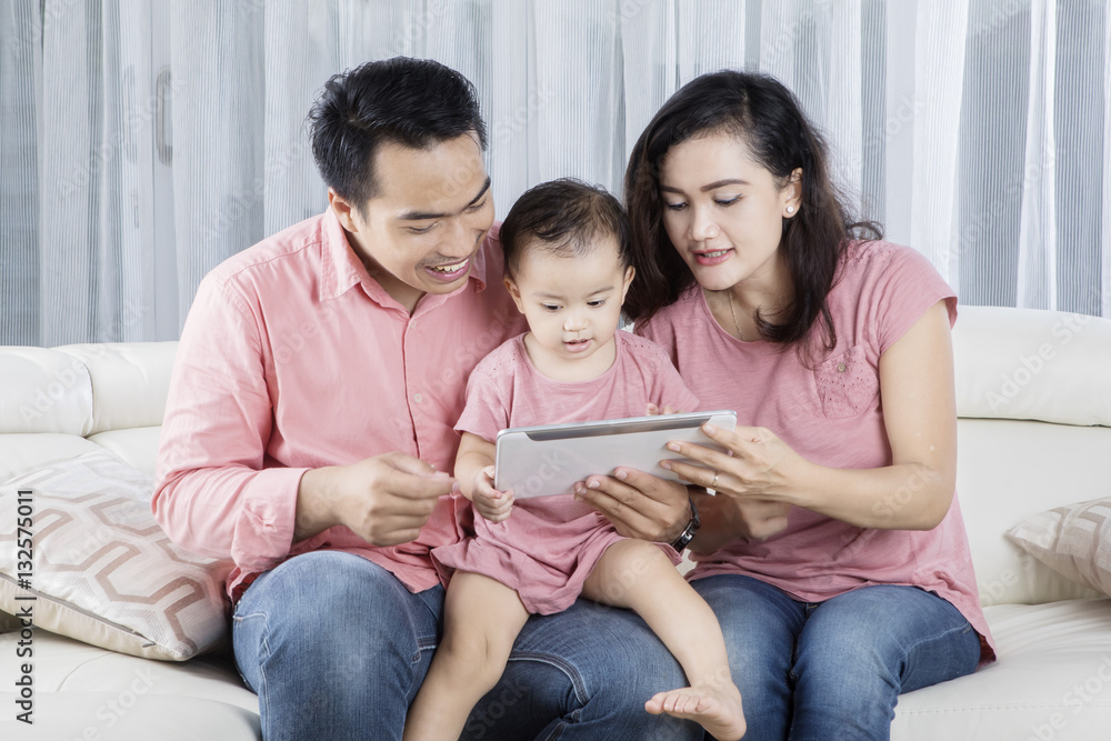 Cheerful family playing digital tablet at home Cheerful family playing digital tablet at home