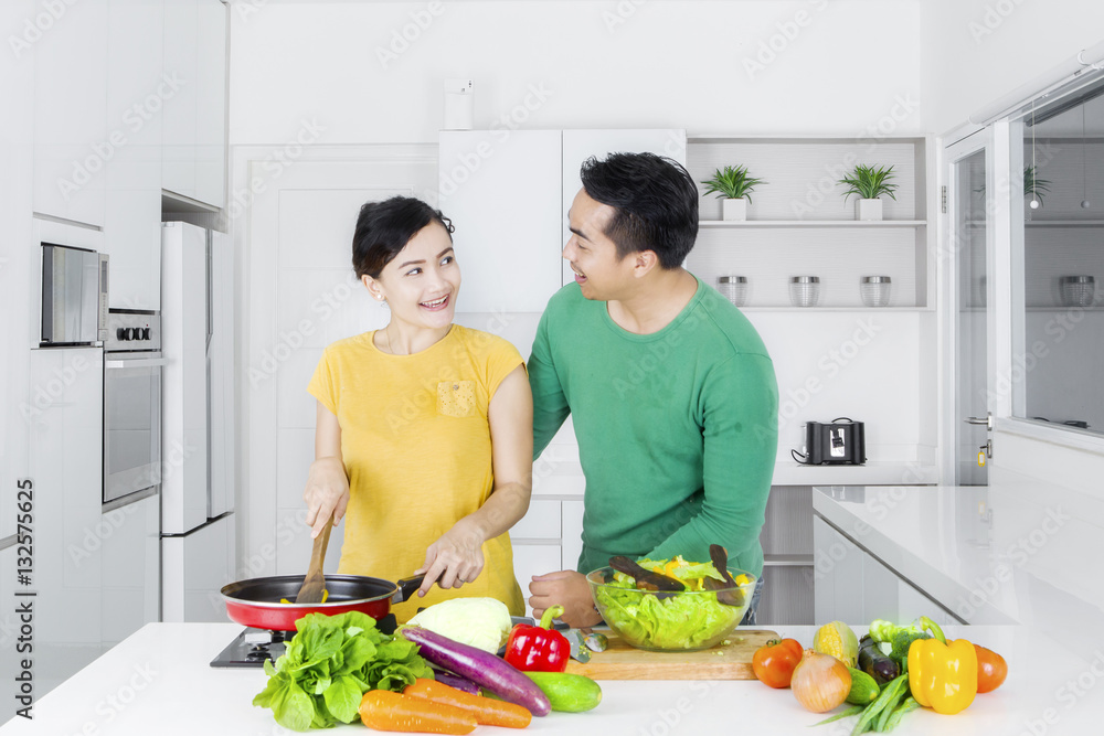 Couple cooking vegetables in kitchen Couple cooking vegetables in kitchen