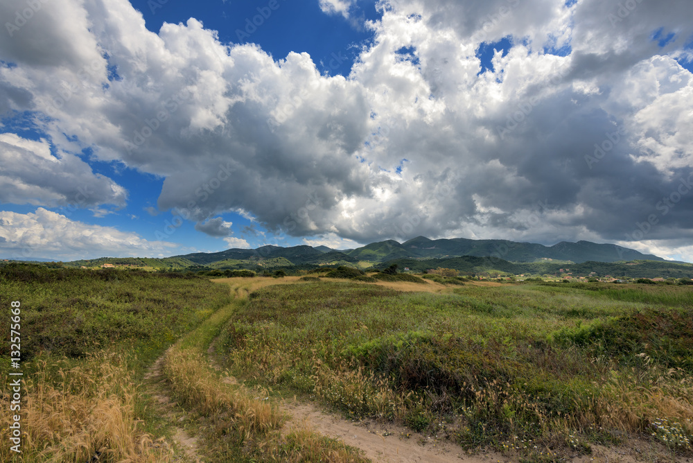 Dramatic clouds over the fields and mountains near the beach in Acharavi village. Corfu island, Greece.