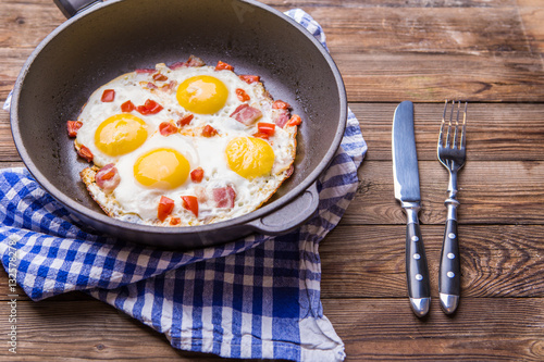 Fred eggs in pan with tomatoes.