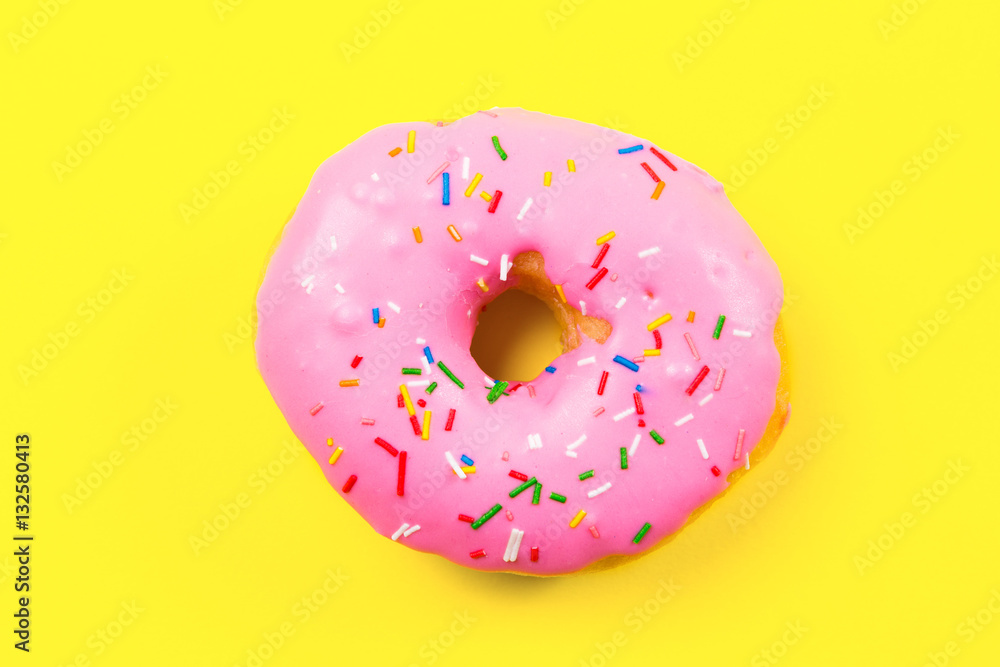 Pink round donut on yellow background. Flat lay, top view. Pink round donut on yellow background. Flat lay, top view.