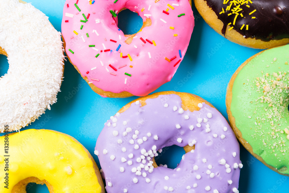 Colorful round donuts on blue background. Flat lay, top view. Colorful round donuts on blue background. Flat lay, top view.
