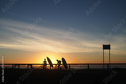 silhouette of surfers at sunrise