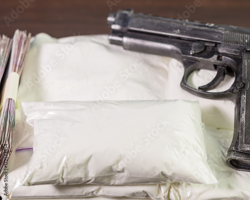 Bags of drugs, pistol and money on table