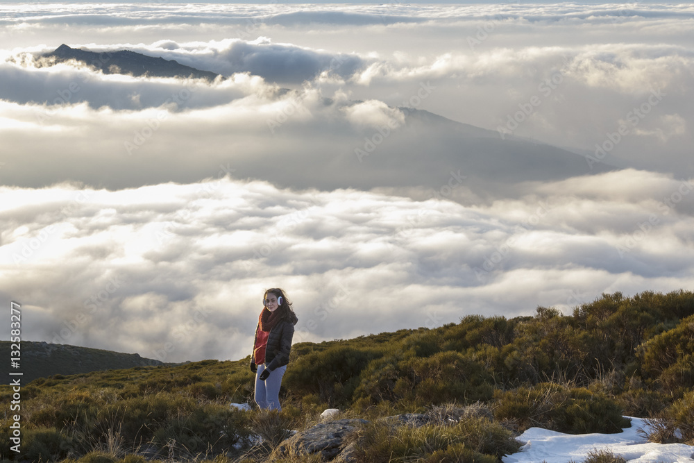 Momentos de libertad. Mujer mirando a cámara en la montaña con el mar de nubes a sus pies