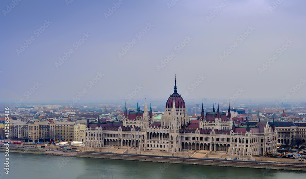 View on the Parliament of Budapest, river Danube and nearby houses on a winter day