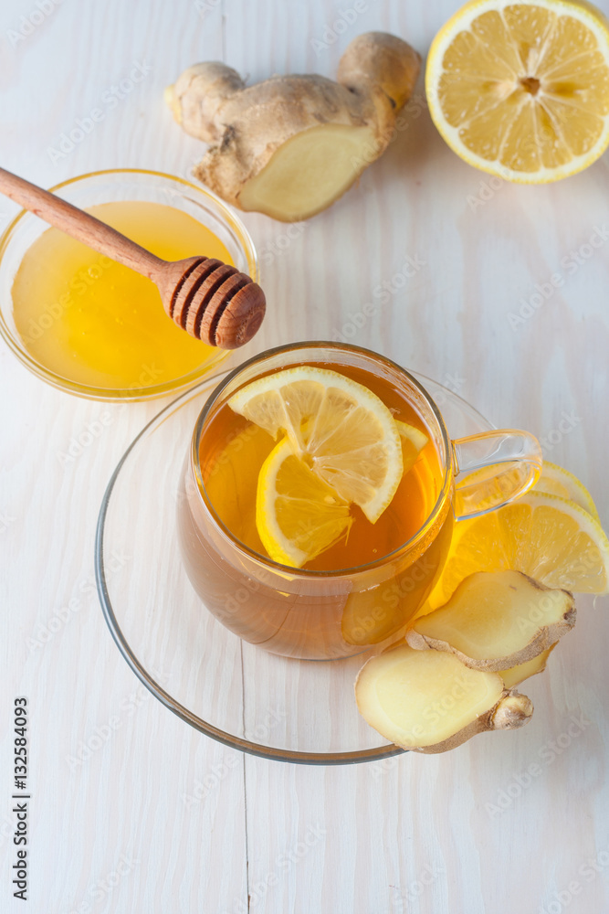 A glass cup of green natural tea with ginger, lemon, mint and honey on wooden rustic background. Healthy drink. A glass cup of green natural tea with ginger, lemon, mint and honey on wooden rustic background. Healthy drink.