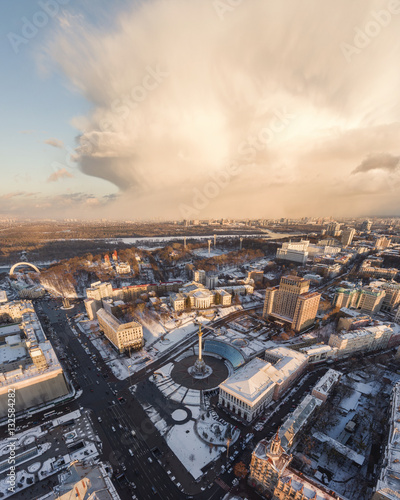 Dramatic winter stormy clouds over city of Kiev, Ukraine. At sunset time, aerial view of Independence Square (Maidan Nezalezhnosti).