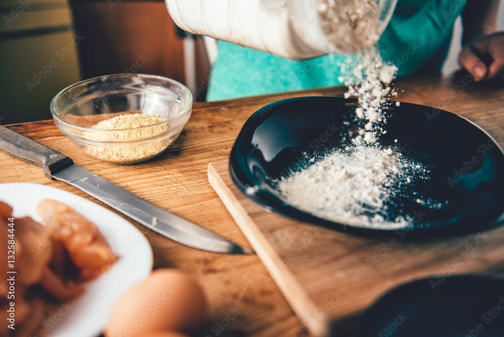Fototapeta premium Woman Pouring breadcrumbs