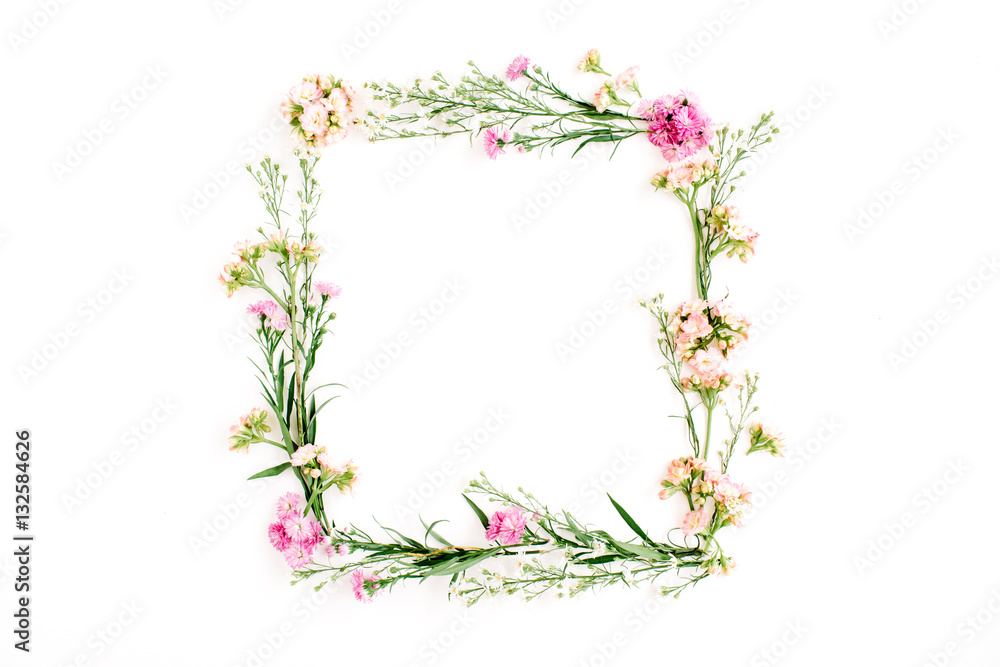Wreath frame made of pink and beige wildflowers, green leaves, branches on white background. Flat lay, top view. Valentine's background
