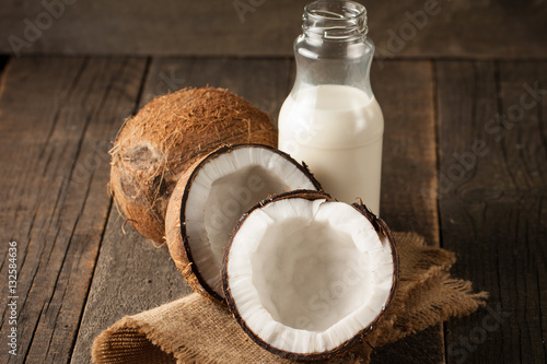 Ripe half cut coconut on a wooden background.