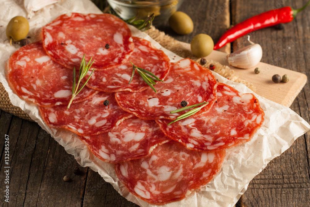 Chorizo sausage and salami, thin cut. spanish salami on the wood background with spices, paprika, pepper. Spicy food. Chili. Chorizo sausage and salami, thin cut. spanish salami on the wood background with spices, paprika, pepper. Spicy food. Chili.