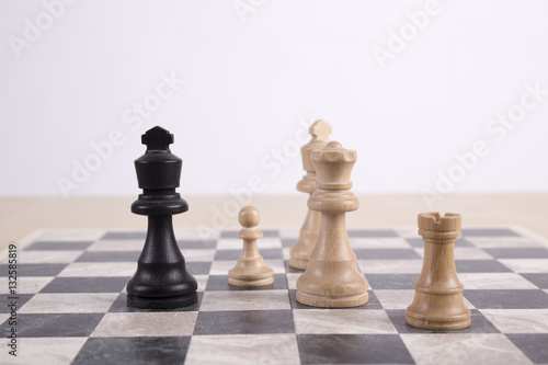 mixed black and white wooden chesspieces on chessboard