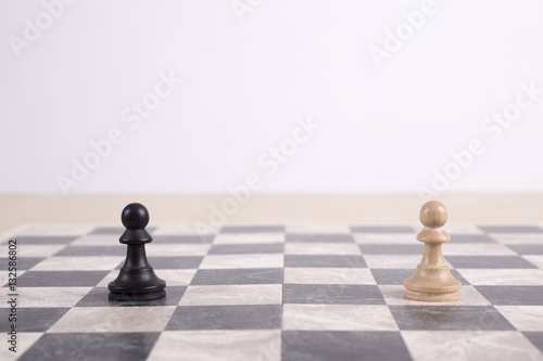 black and white wooden pawns on chessboard