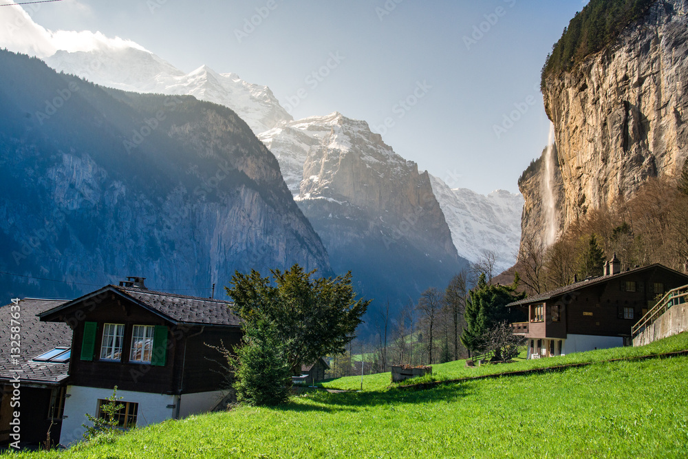Green fields in Lauterbrunnen valley with the waterfall and the Alps in the background, Berner Oberland, Switzerland - April, 2016