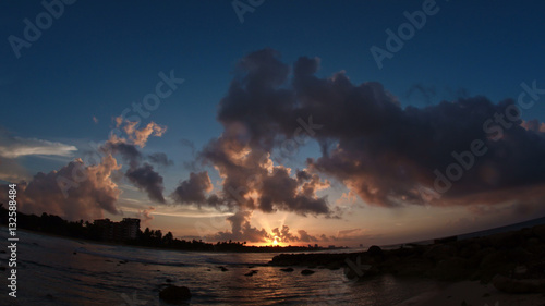 Sunset over sea - caribbean tropical waterfront in clouds