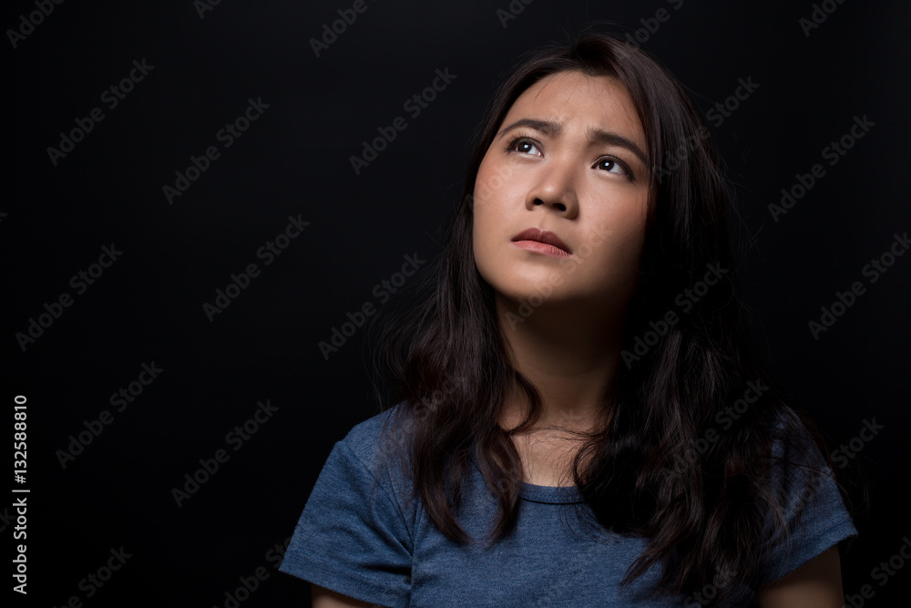 Sad woman on isolated black background