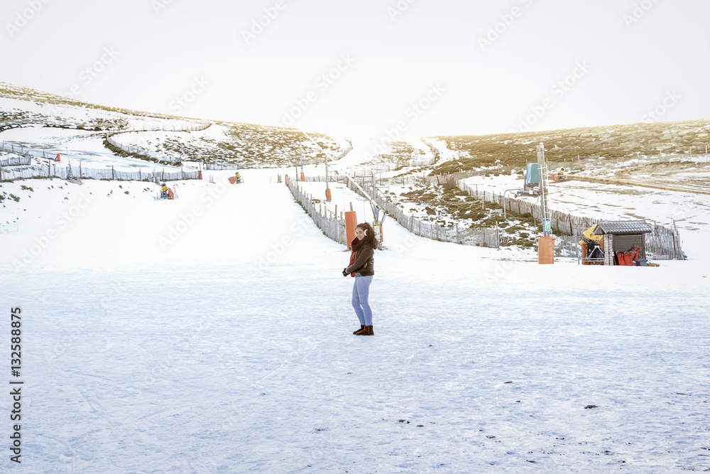 Vacaciones en la nieve. Mujer joven a los pies de la pista de esquí