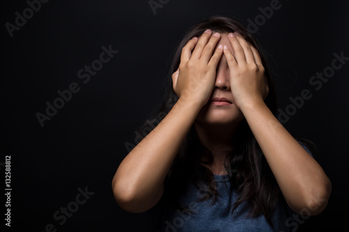 Sad woman on isolated black background