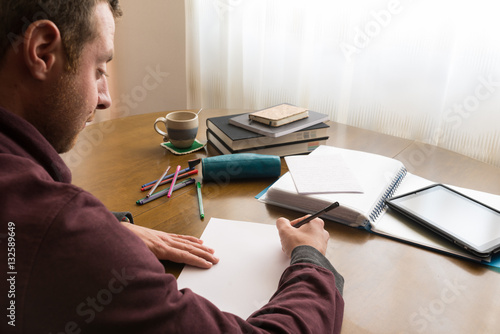 Cuadro en lienzo Hombre joven estudiando en un despacho