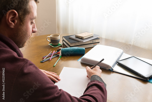 Cuadro en lienzo Hombre joven estudiando en un despacho
