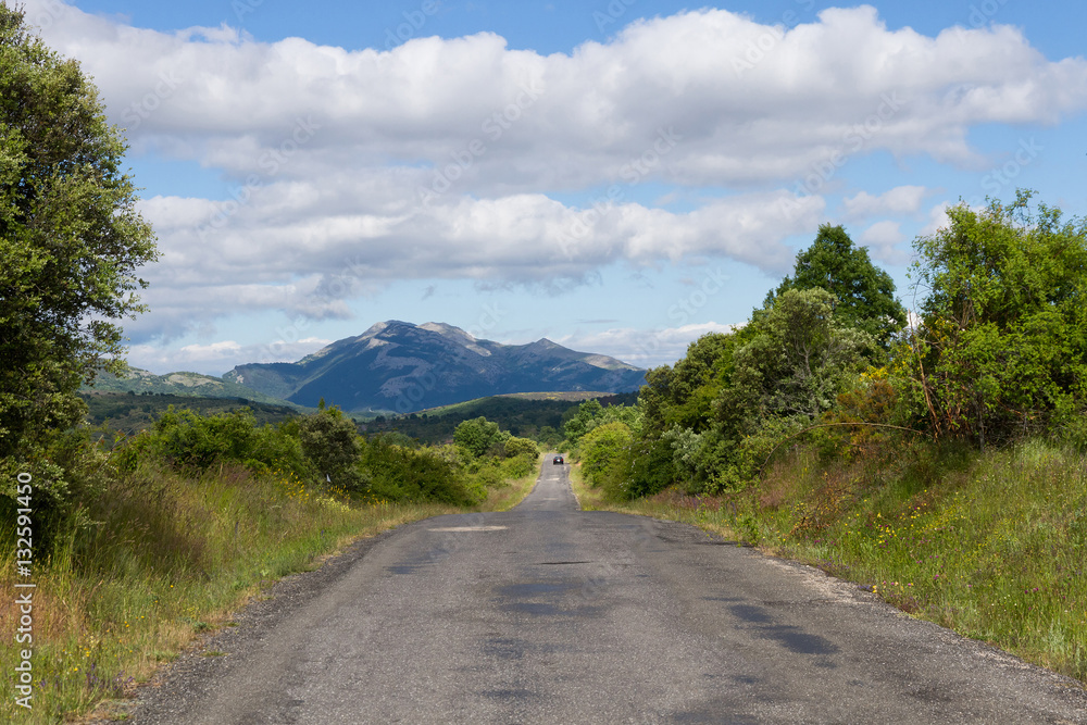 Carretera Secundaria en Paisaje Montañoso  con coche a lo lejos