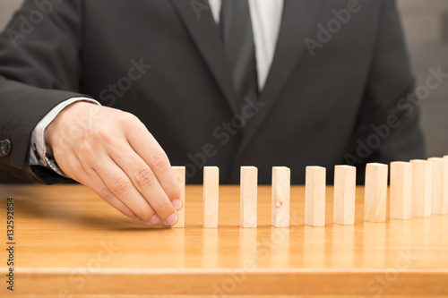Businessman sorting domino wood block