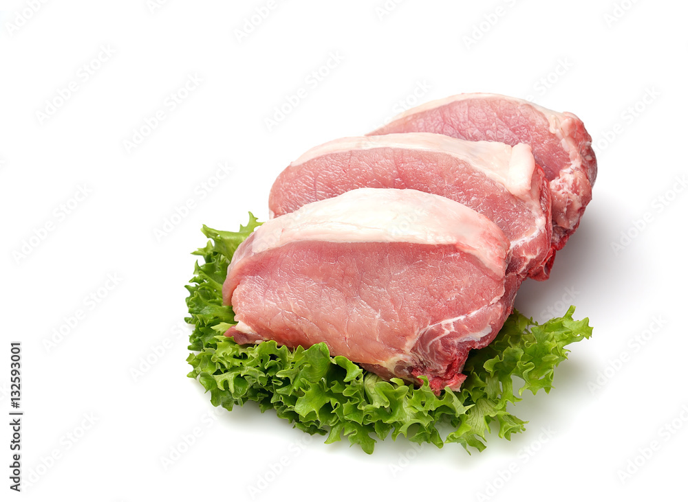 raw pork steaks, lettuce on a cutting board raw pork steaks, lettuce on a cutting board