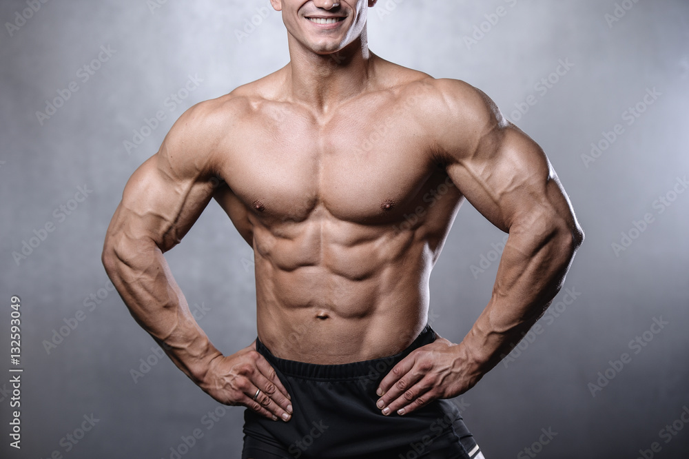 beautiful fitness male model posing in studio on white grey back beautiful fitness male model posing in studio on white grey back